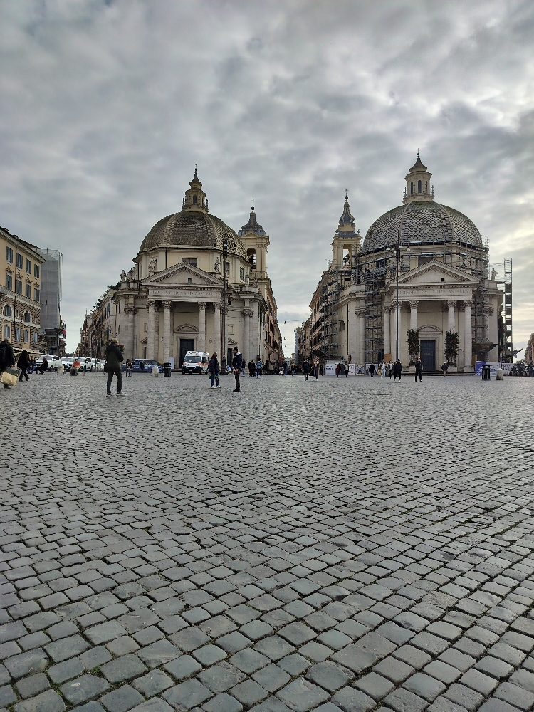 Piazza del Popolo - image of large stone forum with historically domed buildings in the distance